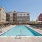a swimming pool surrounded by lounge seating and shaded umbrellas
