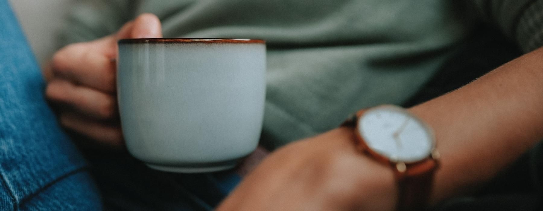 close-up of someone holding a mug of coffee