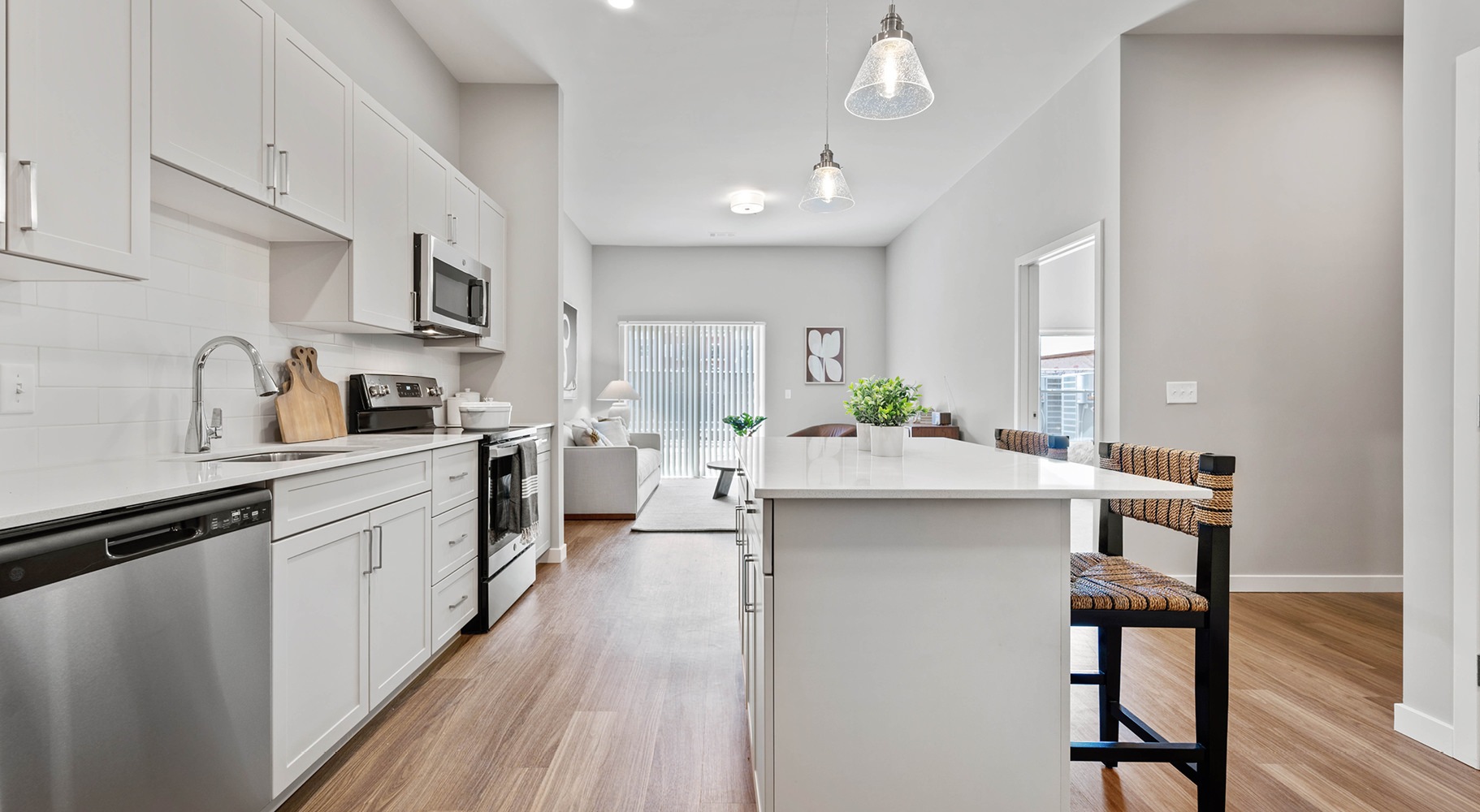 Beautiful kitchens with designer finishes Model kitchen at Millyard at Meadows Commons apartments in Newington, CT, featuring wood grain flooring and a kitchen island.